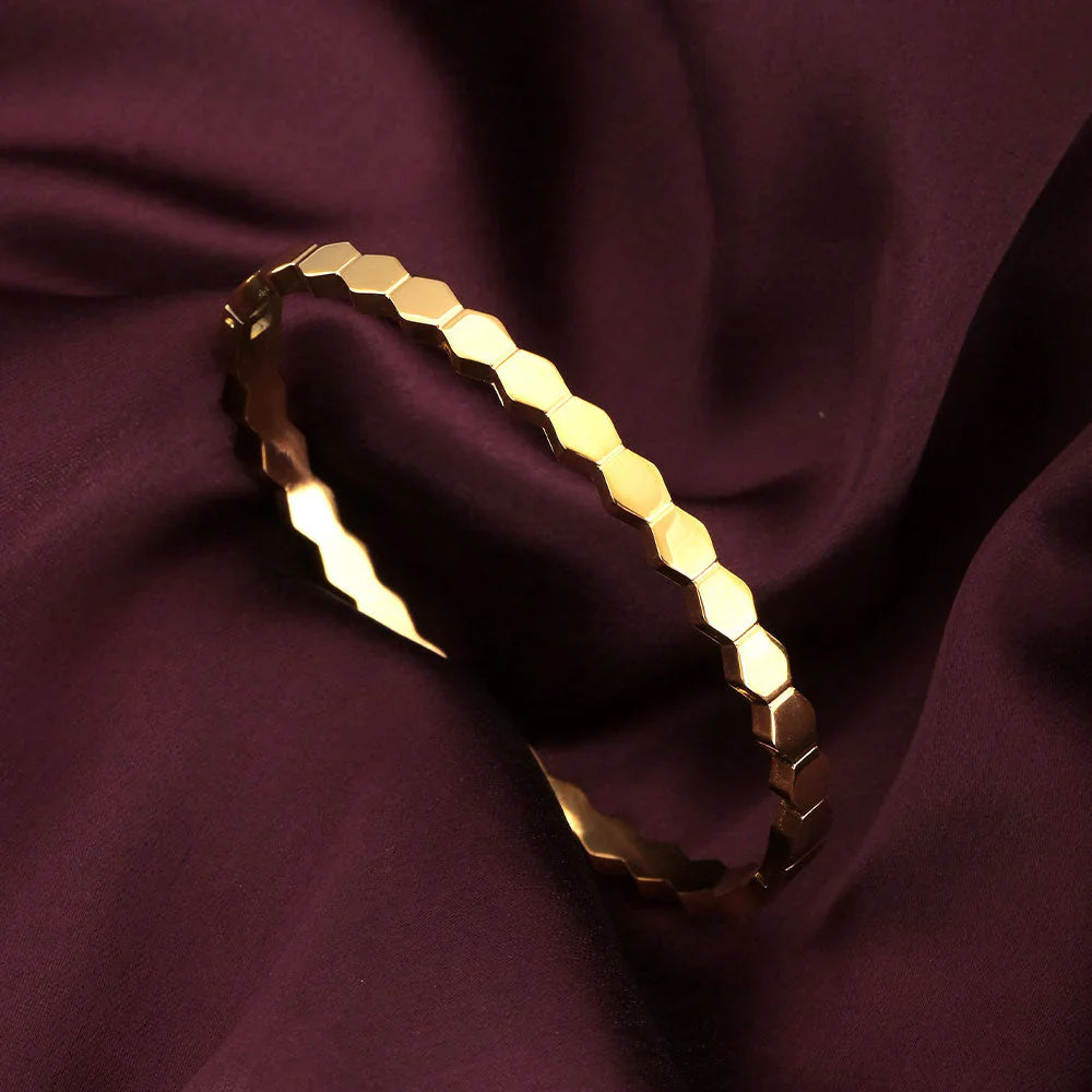 Gold bracelet on a dark purple fabric background